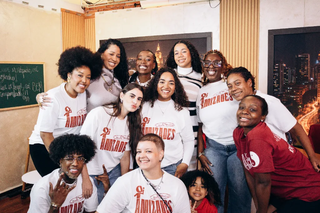 Equipe do Amizades reunida no estúdio, quase todas com a camiseta do programa