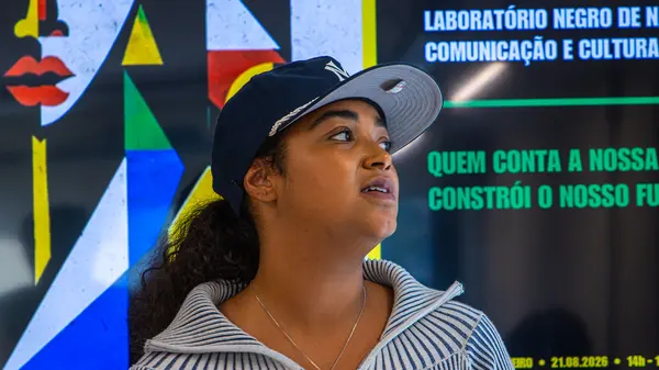 Participante de boné olhando para cima diante do painel do laboratório