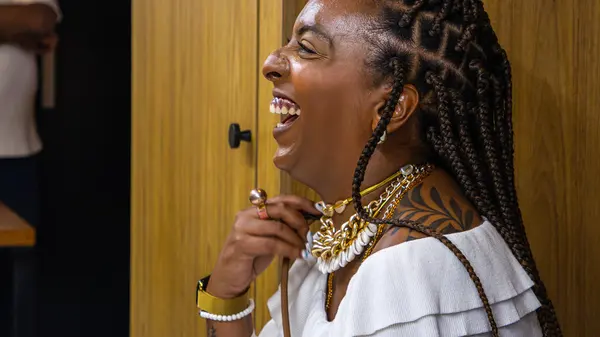 Mulher de tranças rindo durante o encontro